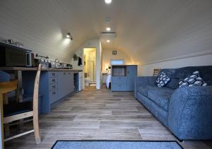 a living room with a couch and a kitchen at Pinemarten Lodge in Roybridge