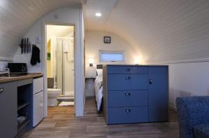 a bedroom with a bed and a blue dresser and a bathroom at Pinemarten Lodge in Roybridge