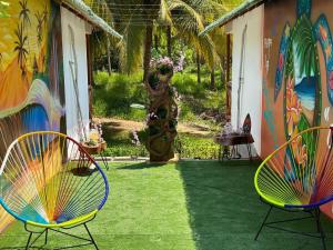 a patio with two chairs and a painting on a house at Casa Aurora Playa La Saladita in La Majahua