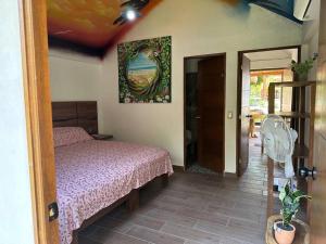 a bedroom with a bed and a fan at Casa Aurora Playa La Saladita in La Majahua