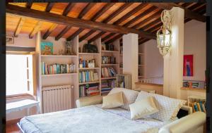 Casale di mamma Antonella في أريتسو: غرفة نوم مع سرير ورف كتاب