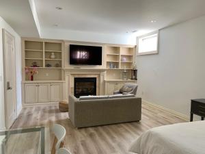 uma sala de estar com um sofá e uma lareira em One Deluxe Bedroom Suite in Midtown em Toronto