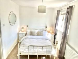 a bedroom with a white bed and a window at Cheerful 2-bedroom home with free parking in Roughhill