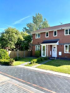 a red brick house with a driveway at Cheerful 2-bedroom home with free parking in Roughhill