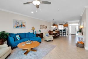 un salon avec un canapé bleu et une table dans l'établissement Three-Bedroom Townhouse, à Marathon