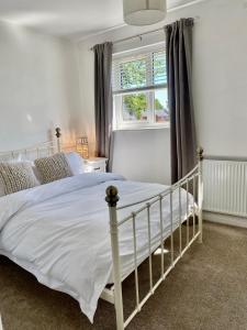 a bedroom with a white bed and a window at Cheerful 2-bedroom home with free parking in Roughhill