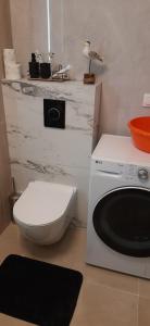 ein Badezimmer mit einem WC und einer Waschmaschine in der Unterkunft Apartament Bosman - Osiedle Beauforta, PARKING FREE in Pogórze