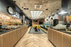 a restaurant with a long counter with yellow chairs at Stawa Apart Hostel in Świnoujście