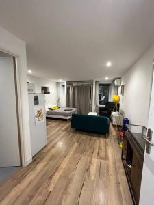 a living room with a blue couch and a kitchen at Studio centre village in Bocognano