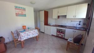 Una pequeña cocina con una mesa y un fregadero. en PS1-A pochi passi dal mare - Baja Sardinia, en Baja Sardinia