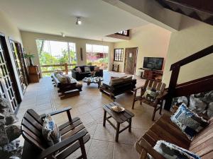 uma ampla sala de estar com sofás e cadeiras em Vista privilegiada para o mar 400 mts da praia em São Sebastião