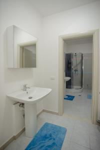 uma casa de banho branca com um lavatório e um chuveiro em City Center Apartment Scutari em Shkodër