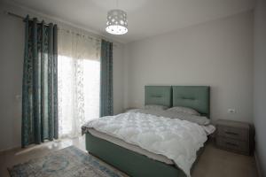 um quarto com uma cama grande e uma janela em City Center Apartment Scutari em Shkodër