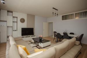 uma sala de estar com um sofá e uma sala de jantar em City Center Apartment Scutari em Shkodër