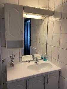 a bathroom with a white sink and a mirror at Cozy apartment in the middle of Bergen city center in Bergen