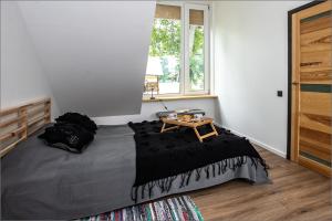 a bedroom with a bed with a table on it at Rytas cozy apartment in the guest house with the terrace and the stunning view to the river side in Birštonas
