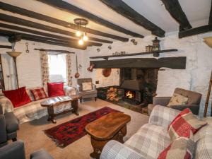 a living room with a fireplace and a couch and chairs at The Old Church House in Newton Abbot