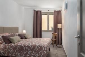 Schlafzimmer mit einem Bett und einem Fenster in der Unterkunft Casa Masoni in Colle di Val d’Elsa