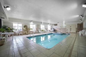 ローリンズにあるComfort Inn & Suites Rawlinsのテーブルと椅子付きのホテルルーム内の大きなプールを提供しています。