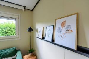 een woonkamer met een groene bank en een raam bij Gezellig ingericht vakantiehuis op de Veluwe in Putten