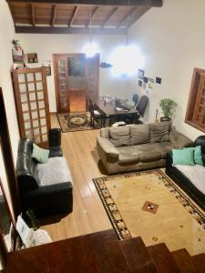 ein Wohnzimmer mit Sofas und ein Esszimmer in der Unterkunft Quarto confortável lago igapó in Londrina