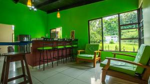 a green room with a bar with green chairs at Green Leaf House in Fortuna