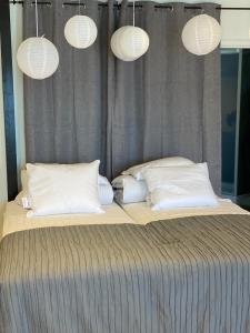 una cama con almohadas blancas y luces sobre ella en Marinan Richters, en Fjällbacka