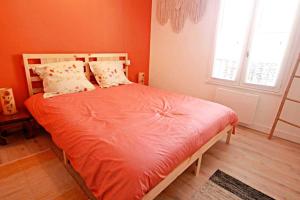 1 dormitorio con 1 cama con sábanas y almohadas de color naranja en Appartement Cathédrale St Front, en Périgueux