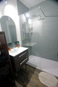 y baño con ducha acristalada y lavamanos. en Appartement Cathédrale St Front, en Périgueux