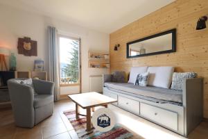 a bedroom with a bed and a chair and a mirror at Le Petit Ours & Le Petit Cerf - Studios vue lac & montagnes in Les Angles