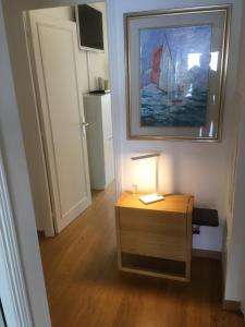 um quarto com uma mesa com um candeeiro e um quadro em Aux portes de Monaco superbe T3 vue mer em Roquebrune-Cap-Martin