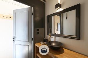 a bathroom with a black sink and a mirror at Le Petit Ours & Le Petit Cerf - Studios vue lac & montagnes in Les Angles