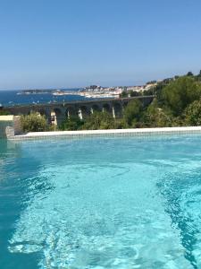 Bazén v ubytování Maison 3 ch 6 pers Sanary vue dominante mer - plage à 400 m - accès piscine - jardin - wifi - terrasse - pergola bioclimatique - climatisation - location par semaine complète nebo v jeho okolí