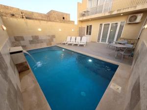 a swimming pool in the middle of a house at Azure W B&B in San Lawrenz