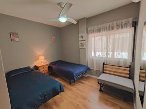 1 dormitorio con 2 camas y ventana en Spot For Golf Lovers Villamartin, en Orihuela