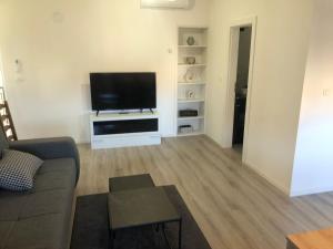 a living room with a couch and a flat screen tv at Apartment Centro 2 in Kastav