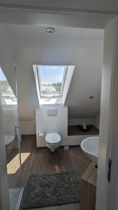 ein Bad mit einem WC, einem Waschbecken und einem Fenster in der Unterkunft Helle Wohnung mit zwei Schlafzimmern in Eching