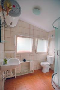 a bathroom with a white sink and a toilet at Domek na Mazurach in Mrągowo