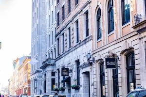 un bâtiment dans une rue avec des voitures garées devant elle dans l'établissement Luxurious condo (1100 sq2) /private elevator!, à Québec