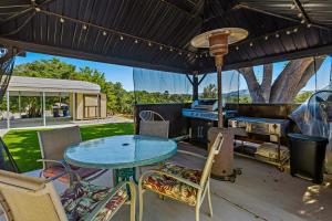 un patio al aire libre con mesa y parrilla en A Retreat to Remember, en Atascadero