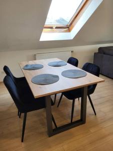 a wooden table with four chairs and a skylight at Zentrale Wohnung in Crailsheim in Crailsheim