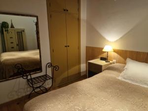 1 dormitorio con espejo grande y cama en El Secreto de Biescas, en Biescas