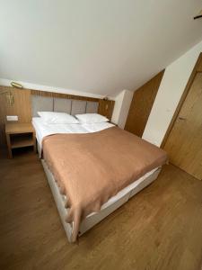 Jabłonki Resort&Spa في Jabłonki: غرفة نوم بسرير كبير مع بطانية بنية اللون