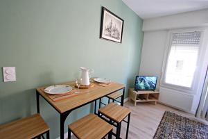 comedor con mesa, sillas y ventana en Appartement Cathédrale St Front, en Périgueux