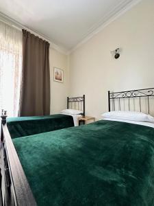 1 dormitorio con 2 camas con sábanas verdes en pardis dormitory en Roma
