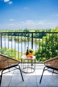 a table and chairs on a balcony with a view of a river at Top View Apart in Iława
