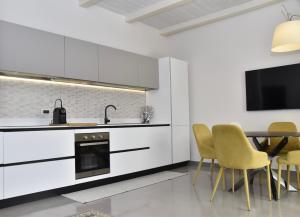 a kitchen with white cabinets and a table and chairs at castel di sangro luxury home in Castel di Sangro