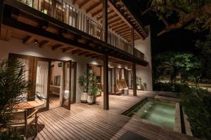 an outdoor deck with a swimming pool and a house at Makani Luxury Wanderlust in Tierra Bomba