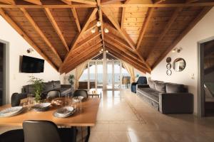 George Beachfront Apartments في Lithakia: غرفة معيشة بسقف خشبي