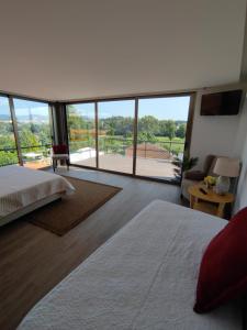 a bedroom with two beds and a large window at Hotel de Charme Casa Fundevila in Vila Verde